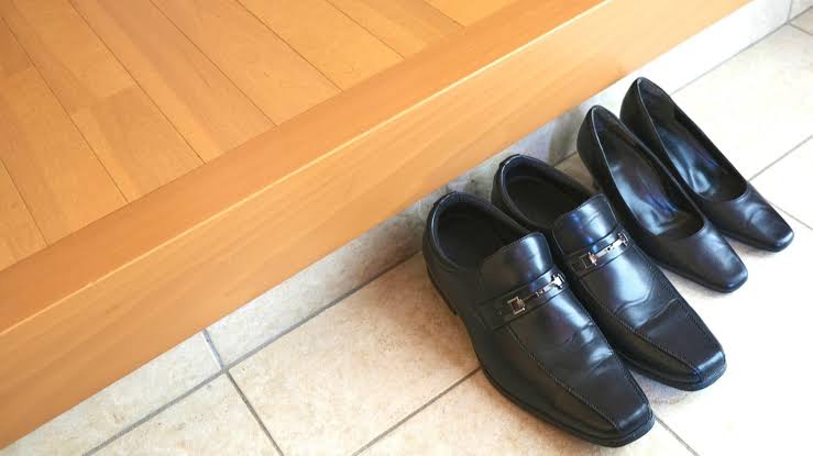 Entrada japonesa con zapatos alineados en el genkan