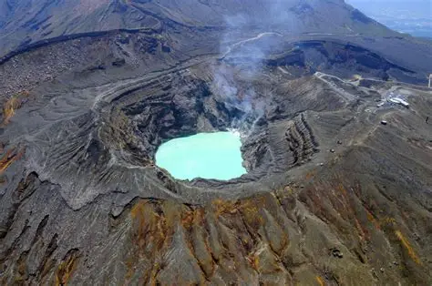 Lago de lava turquesa del cráter Nakadake del Monte Aso con nubes de azufre