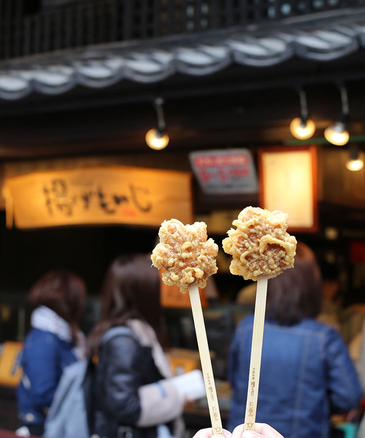 Puestos de momiji manju recién hechos en la isla de Miyajima con el gran torii al fondo
