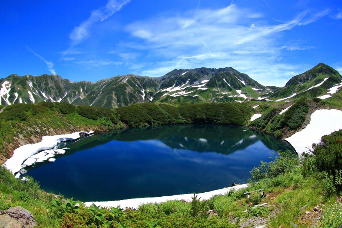 Corredor de nieve de Murodo en el Monte Tateyama con paredes de 20 metros y visitantes en el fondo