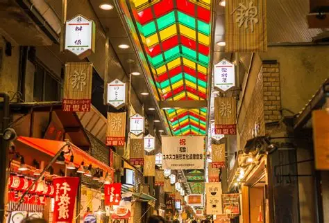 Interior del mercado Nishiki Ichiba de Kioto con puestos de comida y visitantes