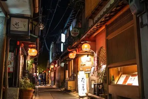 Callejón de Pontocho de noche con linternas rojas y restaurantes en machiya