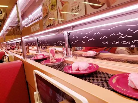Cinta transportadora de Sushiro con platos de sushi colorados pasando ante los comensales